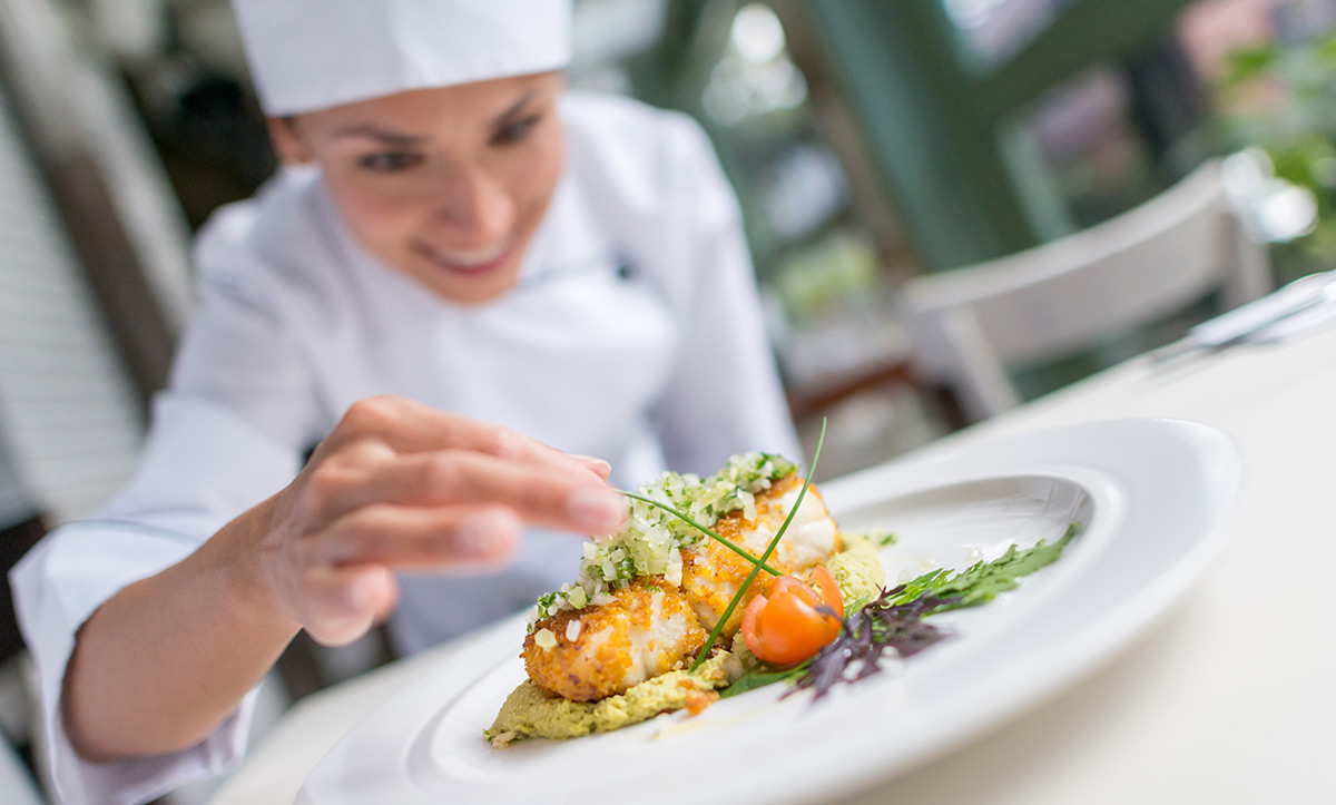 chef putting the finishing touches on a beutiful plate of food at The Estates at Carpenters