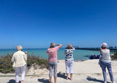Estates at Carpenters - Group of seniors standing on a boardwalk overlooking the beach