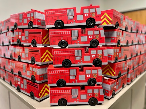 toy fire trucks stacked up on a shelf